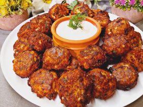 Greek Eggplant Fritters in a plate with sauce - Melitzanokeftedes