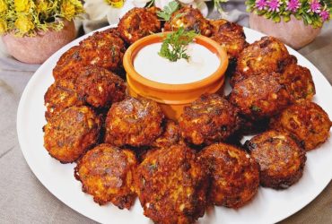 Greek Eggplant Fritters in a plate with sauce - Melitzanokeftedes