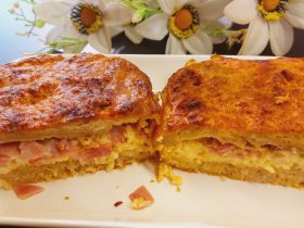 Ζαμπονοτυροπιτα -Two pieces of Greek ham and cheese pie on a plate