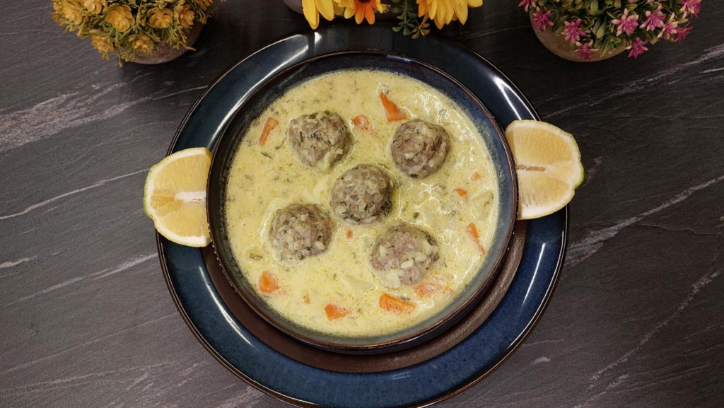 Γιουβαρλάκια Αυγολέμονο σε πιάτο με λεμόνι